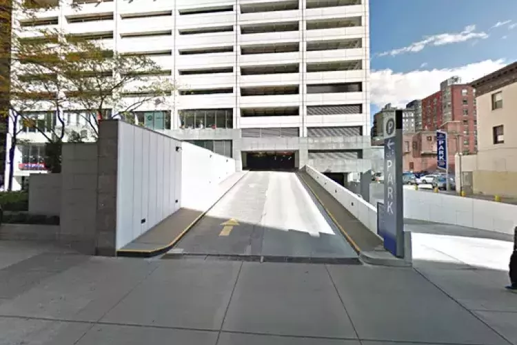 Entrance ramp to the parking garage at 1818 Market, featuring a clearly marked “PARK” sign, clean white retaining walls, and directional arrow guiding vehicles into the covered structure beneath the multi-level facility.